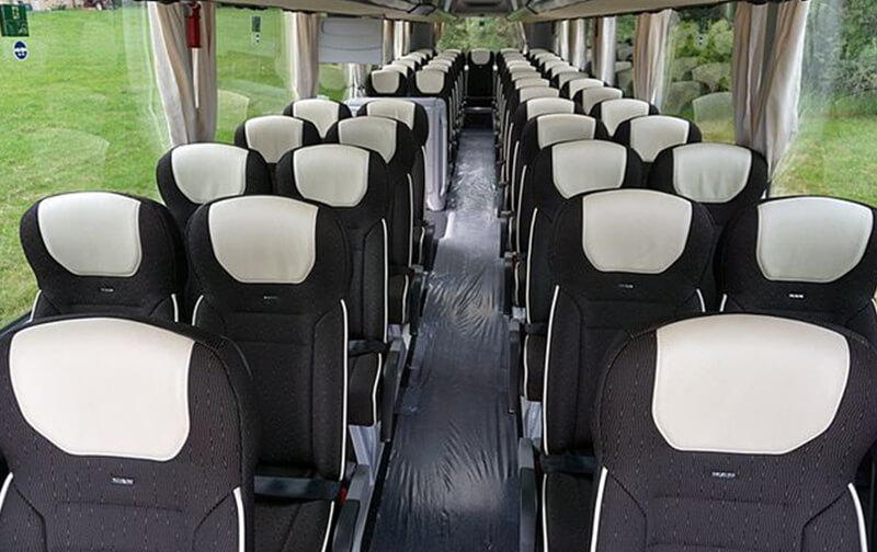 Interior de un autocar con asientos reclinables y pasillo central